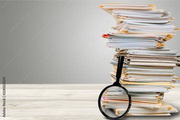 Stack Of Documents With Magnifying Glass
